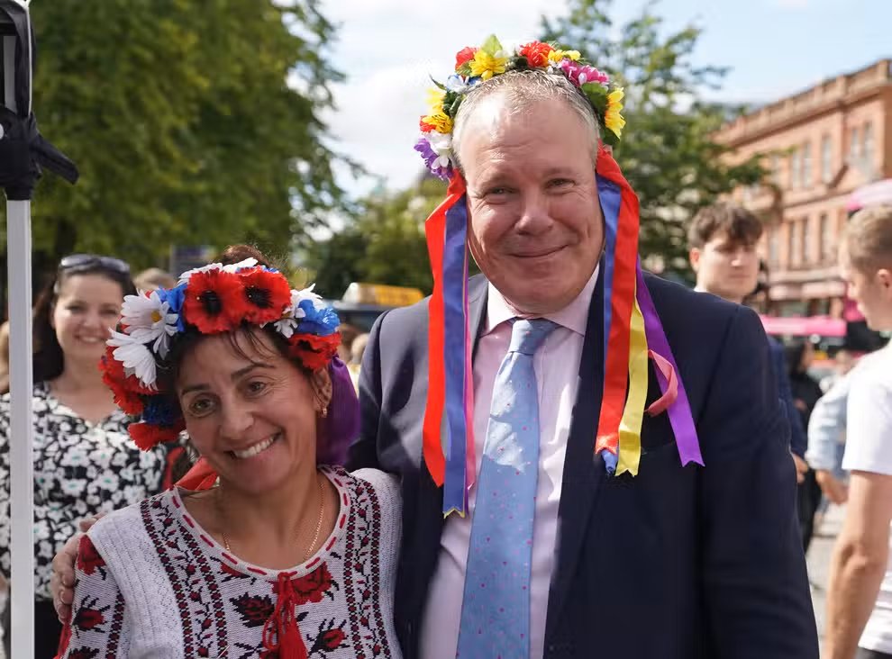 Conor Burns (left), Minister of State for Northern Ireland speaks with Marina Furey from Znamjanka, as he joins Ukrainians celebrating Ukraine independence Day, outside Belfast City Hall (Niall Carson/PA) (PA Wire)
